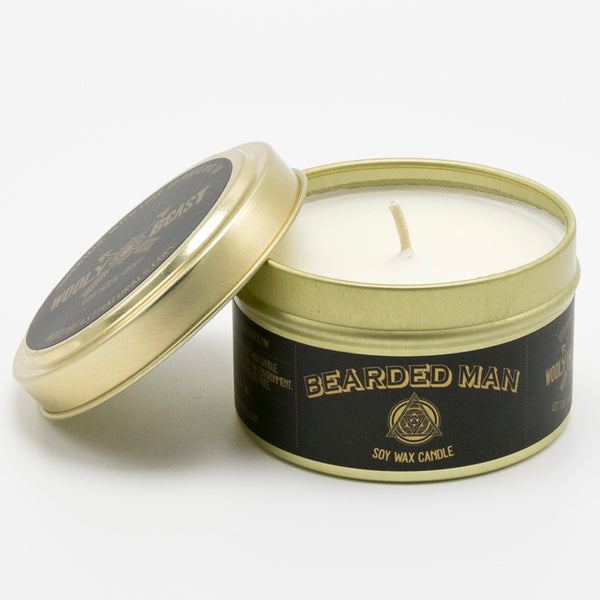 Bearded man scented soy candle in gold travel tin with gold lid is off on white background black and gold label design has sacred geometry and says bearded man soy wax candle
