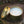 Load image into Gallery viewer, soy wax candle in gold travel tin sitting on tree stump in the woods gold lid leans against the tin