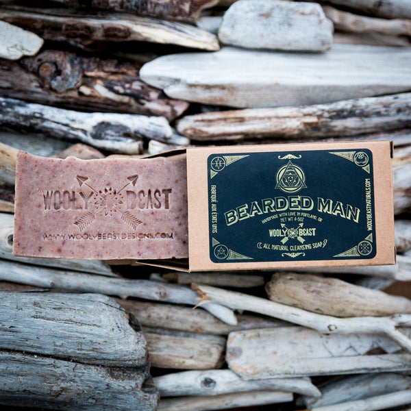 Bearded man natural soap bar coming out of sacred geometry package design box on top of driftwood