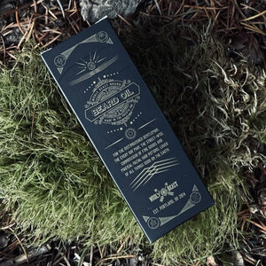 Cult Leader Organic Beard Oil in black box packaging with sacred geometry design lying on moss by Veil+Dagger  Fine Home Goods