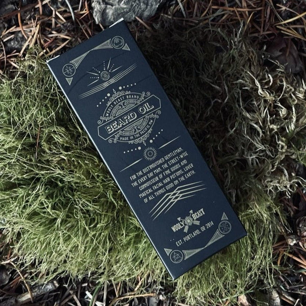 Cult Leader Organic Beard Oil in black box packaging with sacred geometry design lying on moss by Veil+Dagger  Fine Home Goods