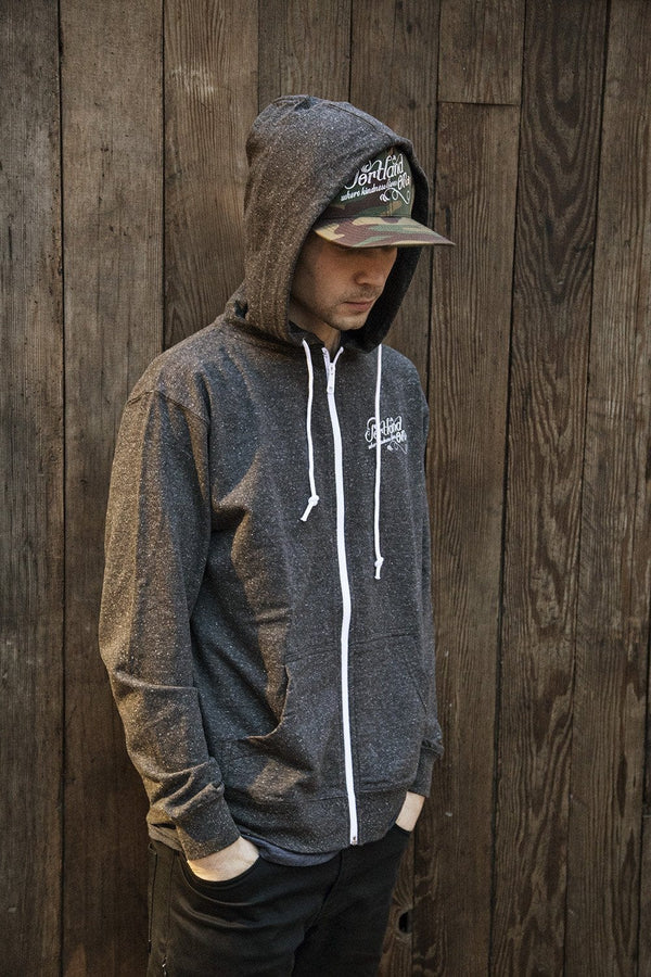 Heather Grey Charcoal Portland Oregon Hoodie on model wearing Portland Oregon hat in front of rustic wood background with hands in pockets