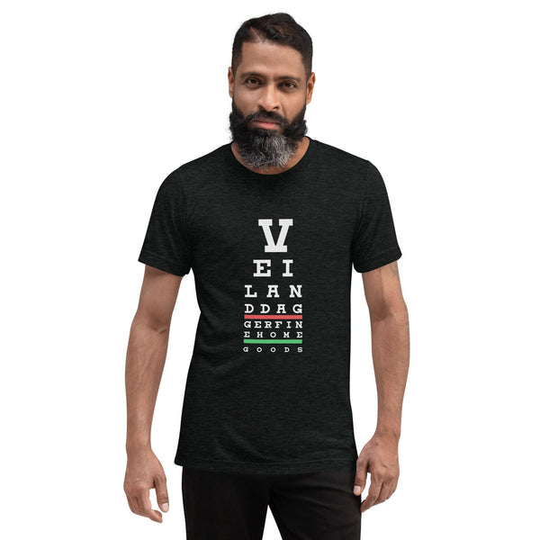 middle aged BIPOC bearded man with dark hair wearing black Eye Chart Mens Tee by Veil & Dagger on white background