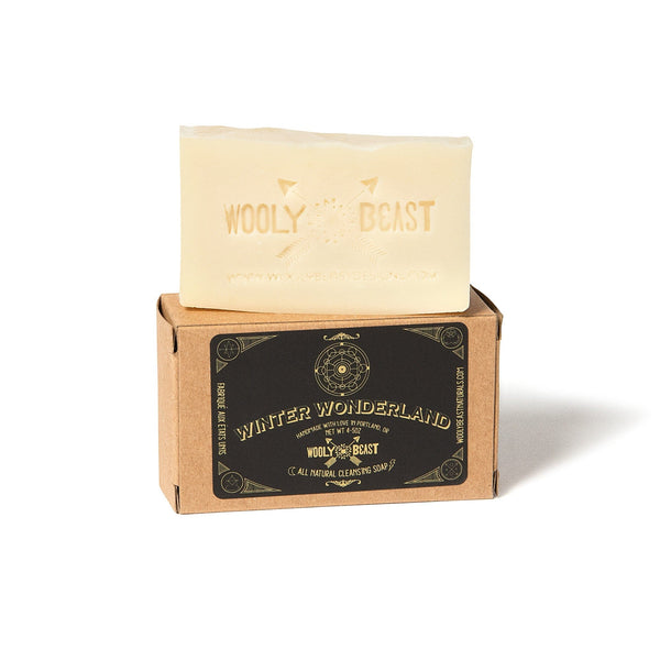 winter wonderland natural bar soap sitting on top of kraft paper box packaging on white background, black and gold label has sacred geometry design and reads Winter Wonderland handmade with love in the pacific northwest, wooly beast, all natural cleansing soap