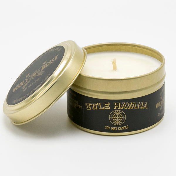 Little Havana Soy Candle in gold tin on white background. Gold lid is off and leaning against it. Black and gold label has sacred geometry design and reads Little havana soy wax candle