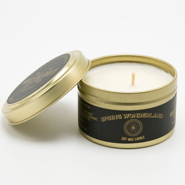 soy candle in gold tin lid leaning on white background, black and gold label has sacred geometry design and reads Spring Wonderland soy wax candle